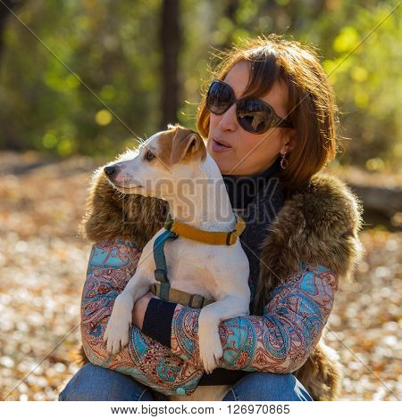 portrait of a woman with a dog on holiday in the autumn park  age of 40 years