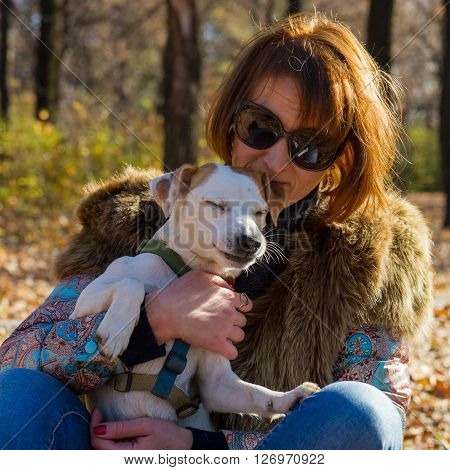 portrait of a woman with a dog on holiday in the autumn park  age of 40 years