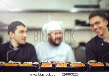 male cooks preparing sushi in the restaurant kitchen.