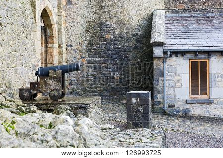 Old cast iron cannon in a castle courtyard