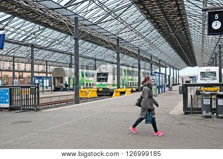 HELSINKI, FINLAND - APRIL 23, 2016: The Central Railway Station. People walk along the platform near the double decker trains (night trains).