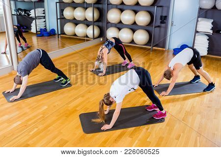 Workout Team Doing Pilates Or Yoga Excerises For Flexibility And Balance At The Fitness Gym.