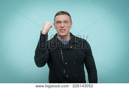 Enraged Nervous Man Threatens Someone With His Fist And Is Making An Admonition Isolated On Blue Bac