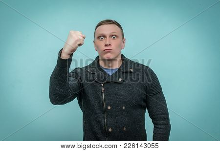 Enraged Nervous Man Threatens Someone With His Fist And Is Making An Admonition Isolated On Blue Bac