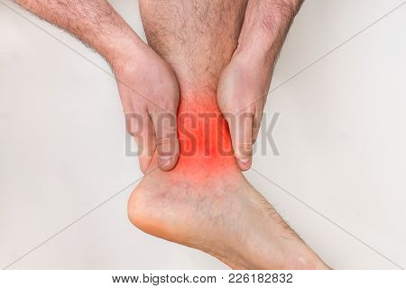 Man With Ankle Pain Holding His Aching Leg - Body Pain Concept