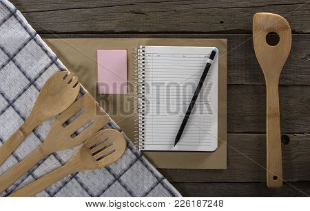 Wooden Kitchen Appliances Napkin And Notebook, On A Wood Background.