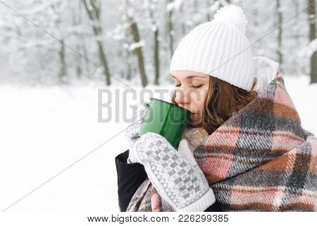 A Girl In A Plaid Drinks Tea In Winter