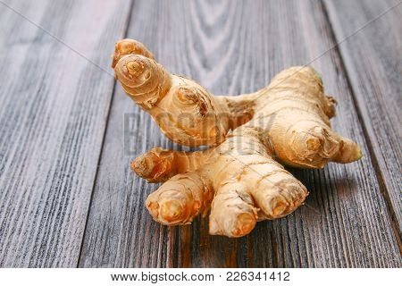 Spicy Root Of Ginger On A Wooden Table