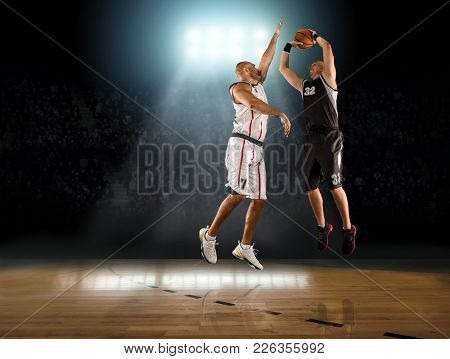 Caucassian Basketball Players in dynamic action with ball in a professional sport game