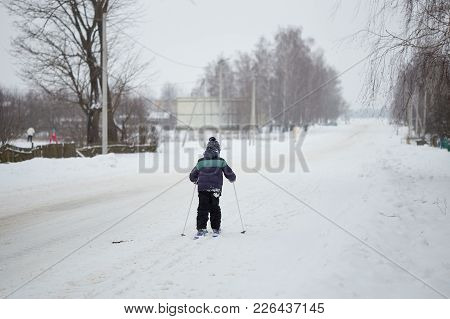 Winter Fun. The Child Is Skiing Around The Village
