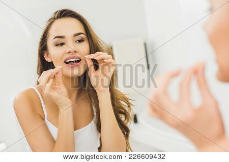 Portrait Of Beautiful Woman Cleaning Teeth With Dental Floss