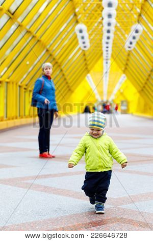 A Funny Emotional Joyful Boy Walks By A Model Gait And Dressed In An Autumn Jacket. Adorable Baby An