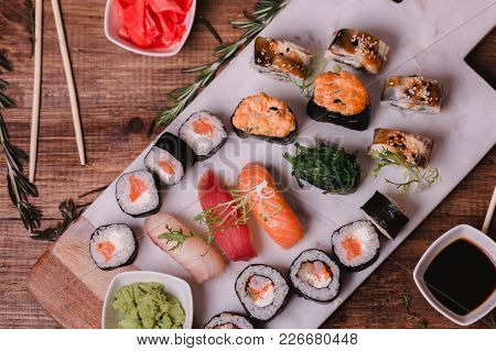 Sushi Set Nigiri And Rolls Served On Brown Wooden Table On Marbel Stone Plate. Top View Food Photogr