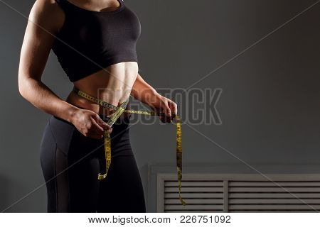 Woman Measuring Her Waistline. Closeup Of Female With Perfect Slim Body And Torso. Healthy Nutrition