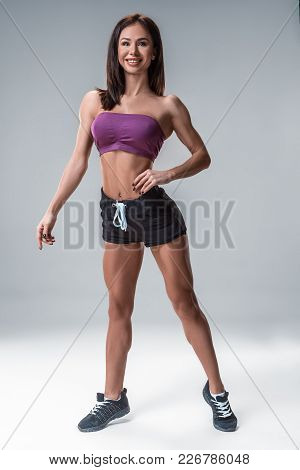 Brunette Sexy Fitness Girl In Sport Wear With Perfect Body In The Studio Posing Before Training Set.