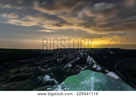 White Cretaceous Hills At Night. Night Landscape With Chalk Mountains Under Cloudy Sky. Natural Arch