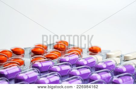 Macro Shot Detail Of Orange, Purple And White Tablets Pills In Blister Pack On White Background. Col