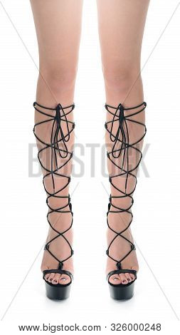 Close-up Of Slim Woman Legs Standing On White Background Wearing Black Platform Heel Gladiator Sanda