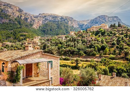 Beautiful Old Town Of Deia With Church Of Saint Joan Baptista On Terraced Hill With High Mountains A