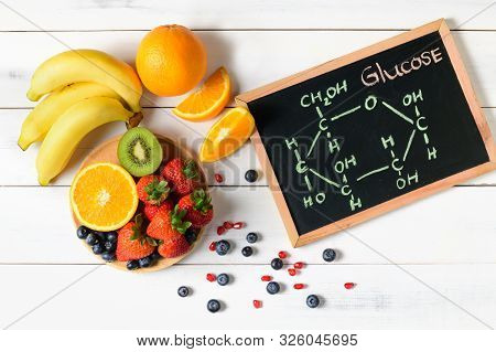 Glucose Molecule On Blackboard With Mixed Fresh Fruits Salad On Wooden White Background, Diet And Fo