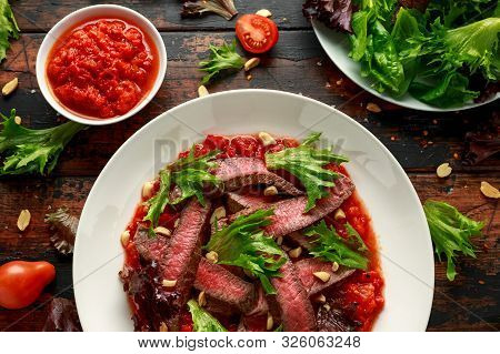 Beef Steak With Romesco Sauce, Nuts And Vegetables On White Plate