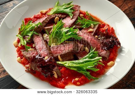 Beef Steak With Romesco Sauce, Nuts And Vegetables On White Plate