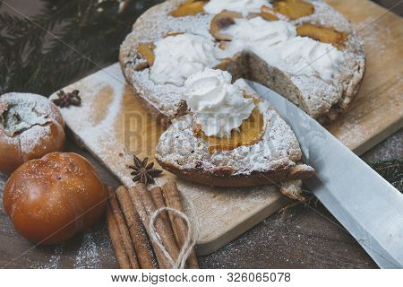 Pie With Persimmon On The Cutting Board, Fresh Persimmon, Knife, Cinnamon, Spruce Branches, Star Ani