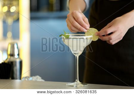 Woman Preparing Fresh Alcoholic Cocktail With Lime And Mint At Bar Counter, Closeup View