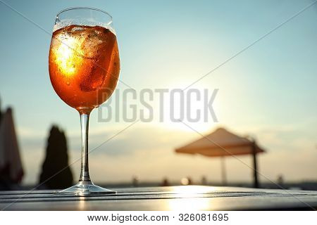 Glass Of Fresh Summer Cocktail On Wooden Table Outdoors At Sunset, Low Angle View. Space For Text