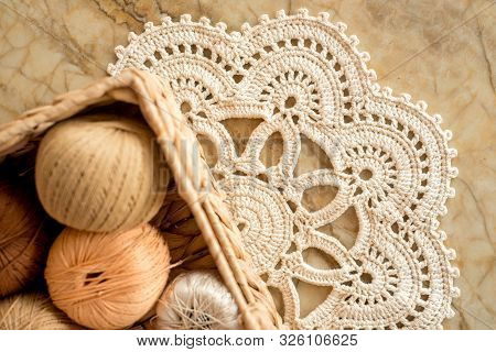 Threads, Crocheted Round Napkin. White Napkin Like A Flower. On A Marble Light Background. Balls Of 