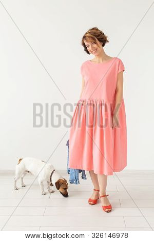 Pet And People Concept - Young Woman In Pink Dress With Jack Russell Over The White Background