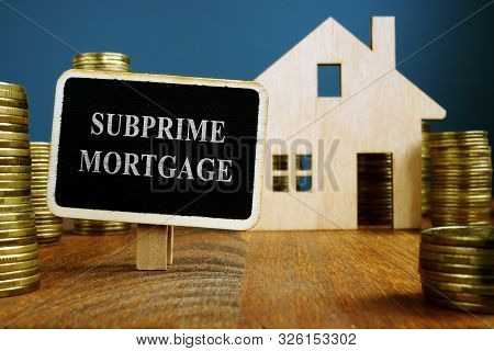 Subprime Mortgage Plate And Model Of Home.