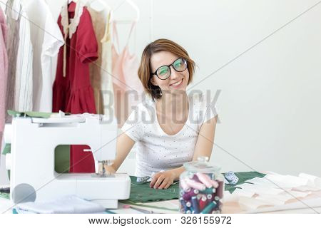 Young Pretty Girl Student Study At A Clothes Designer In College And Does Her First Thesis Sitting A
