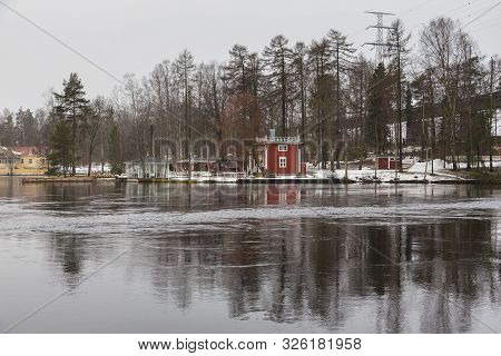 Small, Red, Wooden House On The Bank Ruotsalainen Lake. Winter Landscape, Heinola, Finland.