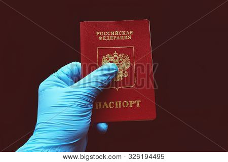 Russian Passport In A Hand In A Blue Glove. The Inscription In Russian: Russian Federation, Passport