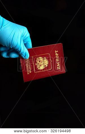Russian Passport In The Hand Of A Border Guard In A Blue Glove. The Inscription In Russian: Russian 