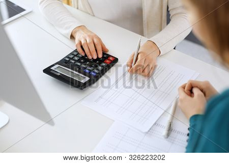 Accountant Checking Financial Statement Or Counting By Calculator Income For Tax Form, Hands Close-u