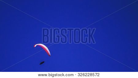 Active Leisure. Parachuting. Parachutist In Cloudless Sky