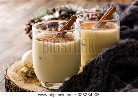 Homemade Eggnog With Cinnamon In Glass On Wooden Table. Typical Christmas Dessert.