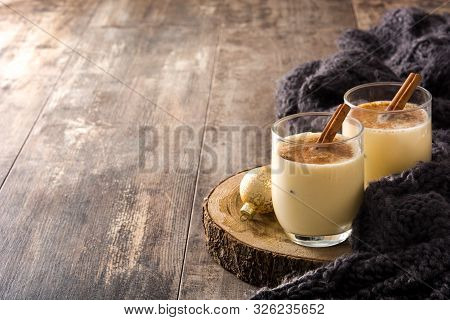Homemade Eggnog With Cinnamon In Glass On Wooden Table. Typical Christmas Dessert. Copy Space