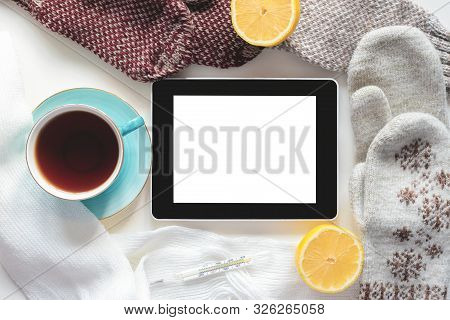 Digital Tablet With Blank Screen With Copy Space, Cup Of Hot Tea, Lemon And Hand With Thermometer On