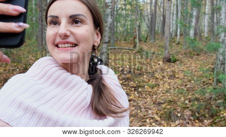 A Young Woman Takes Selfie On The Phone With Pleasure In The Spring Forest And Smiles. Slow Mo. Clos