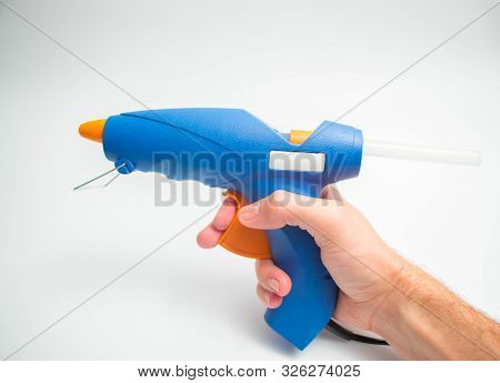 Hot Glue Gun Blue And Orange Close Up And Isolated On White Hand