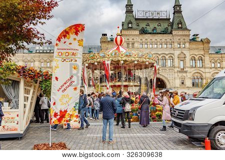 Moscow, Russia - October 05, 2019: View Of Decoreted Two-storey Carousel Against Facade Of Gum State