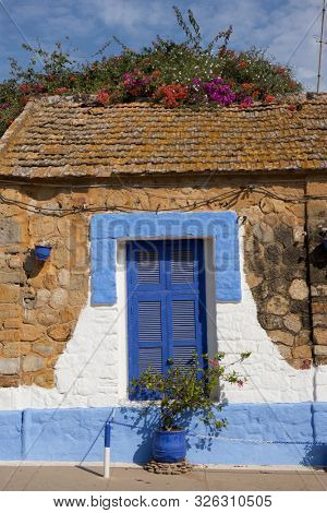  Traditional Moroccan window protected with blue shutters in Assilah, Morocco