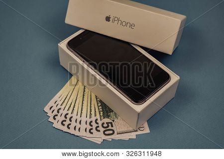 Apple Iphone Devices And Dollars On A Blue Monophonic Background. Voronezh, Russia - May 3, 2019