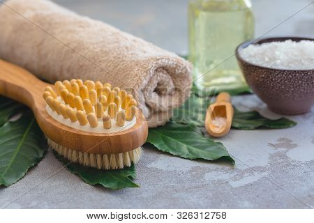 Body Spa Treatment Bamboo Brush With Bathtowel On Green Tropical Leaf, Concrete Background