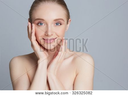 Portrait Of Beautiful Woman With Natural Make Up Touching Her Face.
