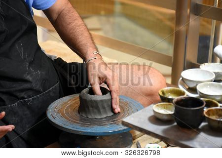 Bangkok, Thailand 08.23.2019: A Thai Artist Is Making A Clay Bowl Very Precisely At The Bangkok Art 