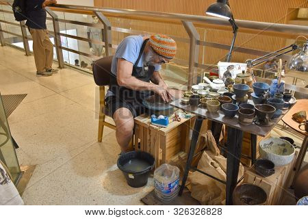 Bangkok, Thailand 08.23.2019: A Thai Artist Is Making A Clay Bowl Very Precisely At The Bangkok Art 